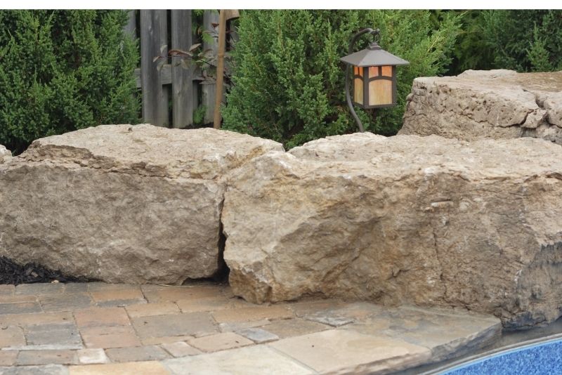 Stones around the pool to brong that rustic feeling. It is also decorated with lighting.